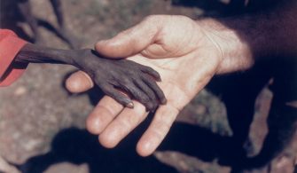 1980. Uganda’da açlıktan ölmek üzere olan bir çocuk ve bir misyoner. Fotoğraf: Michael Wells, İngiltere
